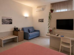 a living room with a blue couch and a flat screen tv at B&B LE MAGNOLIE in Termoli