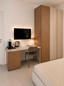 a bedroom with a desk with a tv and a bed at B&B LE MAGNOLIE in Termoli