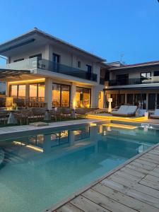 a house with a swimming pool in front of a house at SunSet Boutique Hotel in Neos Marmaras