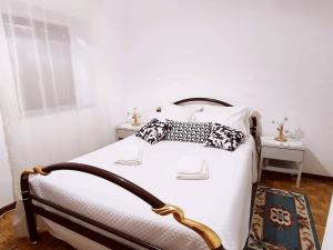 a bedroom with a bed with white sheets and pillows at Casa do Centro - Alojamento Local in Vieira do Minho