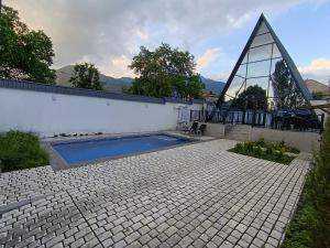 a house with a swimming pool and a pyramid at Gabala A frame Guest villa in Gabala