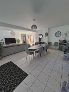 a dining room and living room with a table and chairs at Villa La Digue in Plobsheim