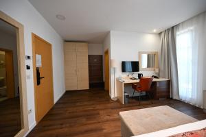 a hotel room with a desk and a bed and a deskictericter at Boutique Hotel Ukus in Tešanj