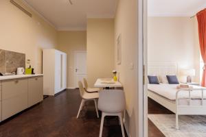 a small apartment with a bed and a table and chairs at #Artistic Flat 2BR Historical Center Timișoara in Timişoara