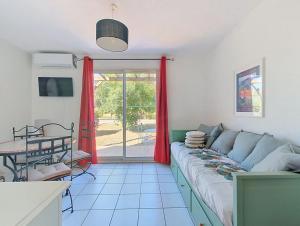 a living room with a couch and a table at Cottage clim piscine in Saint-Saturnin-lès-Avignon