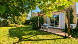 a garden with a table and chairs on a patio at Cottage clim piscine in Saint-Saturnin-lès-Avignon