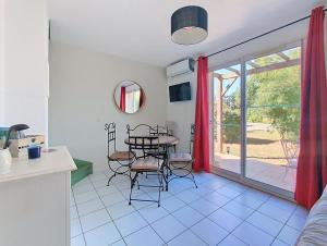 a kitchen and dining room with a table and chairs at Cottage clim piscine in Saint-Saturnin-lès-Avignon