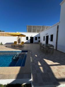 a patio with a table and chairs next to a building at Villa Zina s3 in El Mây