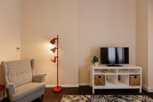 a living room with a tv and a chair at #Artistic Flat 2BR Historical Center Timișoara in Timişoara