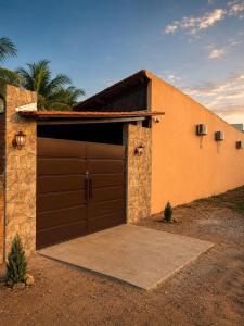 a garage with a brown garage door in front of a house at Pousada Refúgio Encantado-Cavernas do Peruaçu in Itacarambi