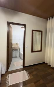 a bathroom with a door leading to a bathroom with a sink at Pousada Refúgio Encantado-Cavernas do Peruaçu in Itacarambi