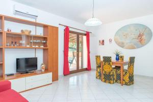 a living room with a tv and a table and chairs at Résidence Villa Smeralda in Telti