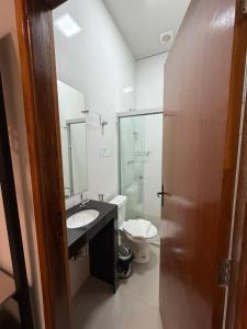 a bathroom with a sink and a toilet at Him Hotel in Iraí de Minas
