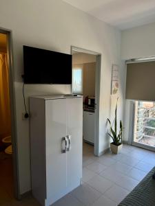 a kitchen with a refrigerator with a flat screen tv at Cid Movistar Arena in Buenos Aires