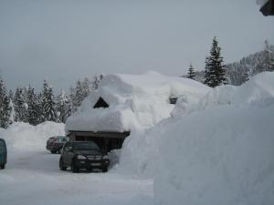 stos śniegu na dachu samochodu w obiekcie Haus Serena oben w mieście Sonnenalpe Nassfeld