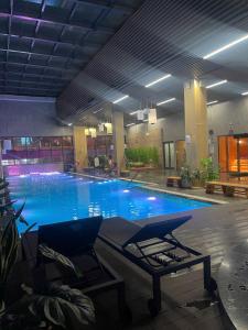 a large swimming pool with blue water in a building at Flamingos Hải Tiến LUXURY view biển tầng cao và Biệt thự 4pn in Thanh Hóa