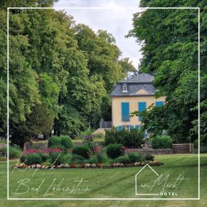 a house in the middle of a yard with flowers at Hotel am Markt in Bad Lobenstein