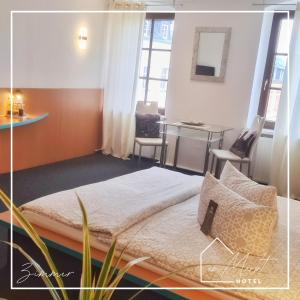 a bedroom with a bed and a table and chairs at Hotel am Markt in Bad Lobenstein +41 photos