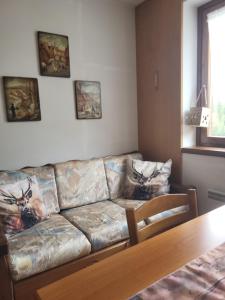 a leather couch in a living room with a table at Casa Bella Vista in Foppolo