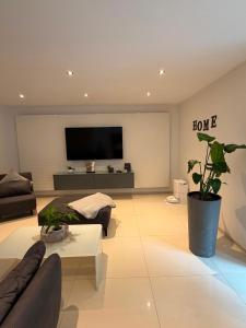 a living room with a couch and a flat screen tv at Beautiful living in Schönaich