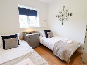 a bedroom with two beds and a clock on the wall at The Lilac Owl in Lincoln
