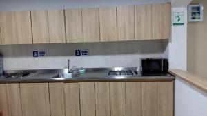 a kitchen with a sink and a microwave at Lux Al Wafa in Bogotá