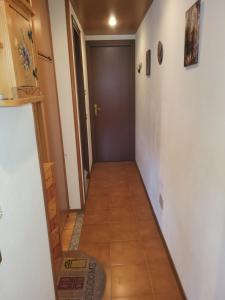 a hallway with a door and a tile floor at Casa Bella Vista in Foppolo