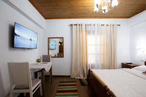 a bedroom with a bed and a table and a television at Kashah Residence in Gjirokastër
