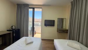 a hotel room with two beds and a television at Selena Hotel Aqaba in Aqaba