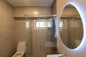 a bathroom with a mirror and a toilet and a sink at Stellasrooms in Mytilene