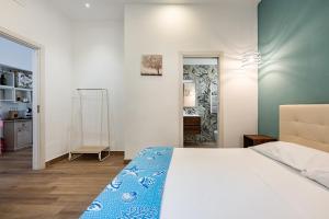 a bedroom with a bed with a blue blanket on it at Aroma Rooms Procida in Procida