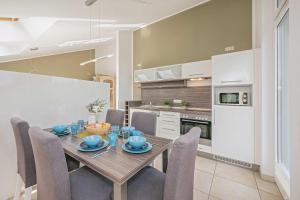 a dining room with a table and chairs in a kitchen at Haus Ostseekristall Wohnung Rubin in Zinnowitz