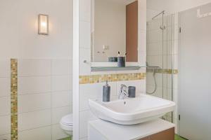 a white bathroom with a sink and a toilet at Haus Ostseekristall Wohnung Rubin in Zinnowitz +20 photos