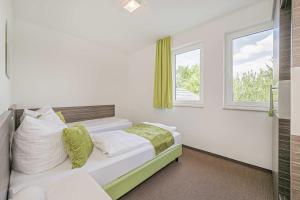 a bedroom with a bed and a window at Haus Ostseekristall Wohnung Rubin in Zinnowitz