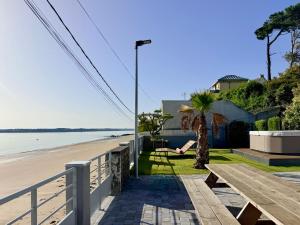 a person sitting on the beach next to a street light at Beach house Maison de plage les pieds dans l eau in Plérin