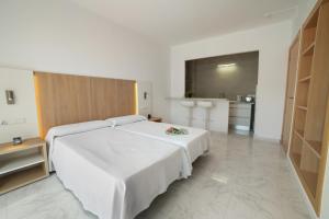 a hotel room with two beds and a kitchen at Apartamentos Playa Sol in Es Cana