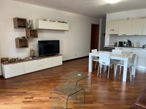 a living room with a dining table and a kitchen at Little Venice in Sacile