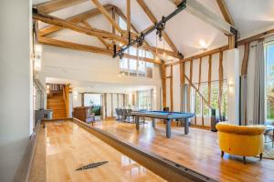 a living room with a ping pong table in the middle at Wolmers Barn in Stonham Aspall