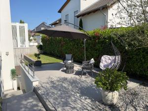 a patio with two chairs and an umbrella at Beautiful living in Schönaich