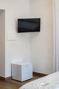 a flat screen tv hanging on a white wall at Aroma Rooms Procida in Procida +57 photos