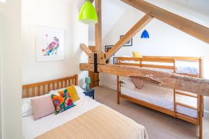 two bunk beds in a room with a loft at Wolmers Barn in Stonham Aspall