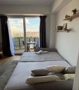 a large bed in a room with a large window at City nest Skopje in Skopje