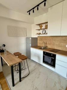 a kitchen with a table and a sink and a stove at City nest Skopje in Skopje +8 photos