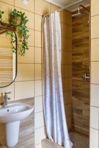 a bathroom with a shower curtain and a sink at Szyszkowy Domek in Milejczyce +31 photos