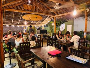 a group of people sitting at tables in a restaurant at Blue Wings Arugam Bay in Arugam Bay +19 photos