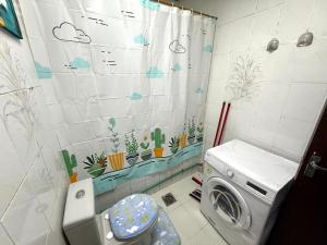 a bathroom with a washing machine and a shower curtain at المرور ابو ظبي in Abu Dhabi