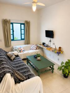 a living room with a couch and a table at Piratas Guest Rooms II in Búzios