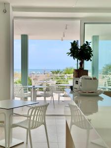 a dining room with white chairs and a table at Hotel Royal Garnì in Caorle
