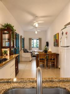 a kitchen and living room with a table and a couch at Piratas Guest Rooms II in Búzios