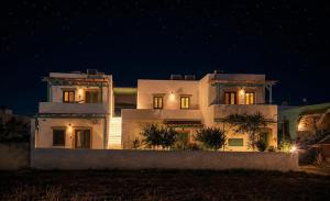 a large white house at night with lights on at Apocalypsis Houses in Skala